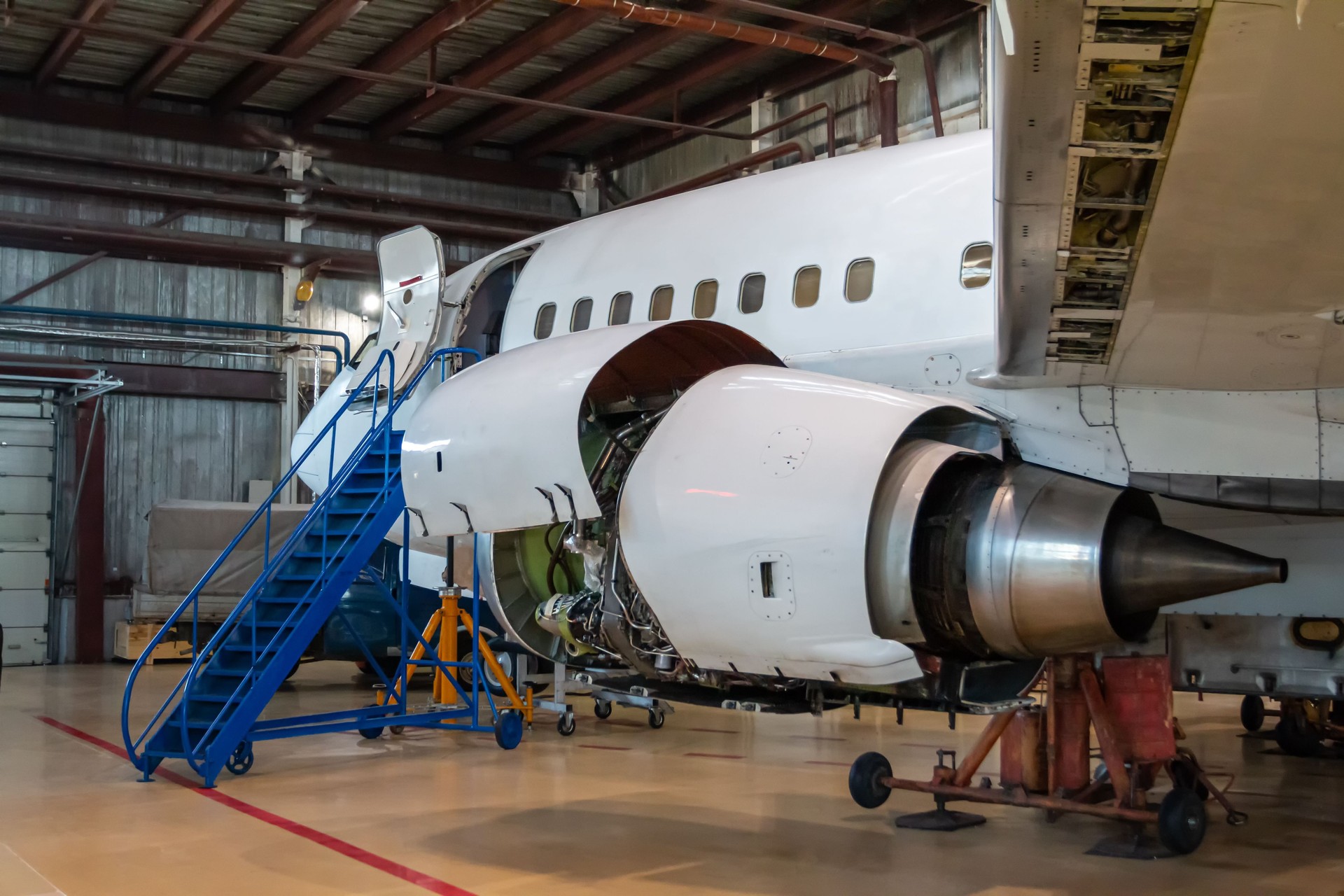 White passenger aircraft in the aviation hangar. Jetliner under maintenance